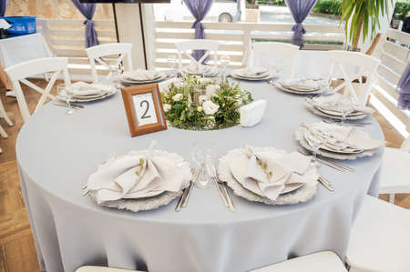 A very beautiful festive table with candles, plates and glasses. Cool room decor