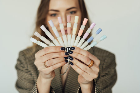 Professional woman master of manicure posing with samples of nails. The nail technician holds the sample palette.の写真素材