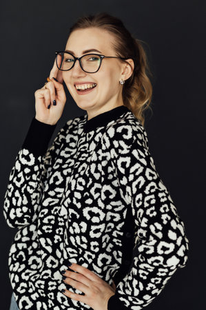 Beautiful girl in glasses looks at the camera and smilesの写真素材