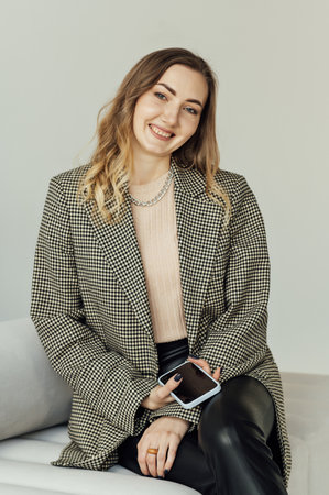 Woman psychologist sits on the couch and communicates in social networks with her clientsの写真素材