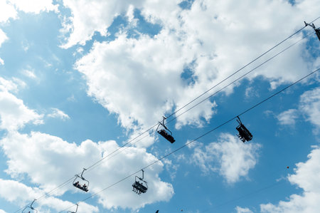 Mountain four-seater chairlift on the background of a blue cloud sky.の写真素材