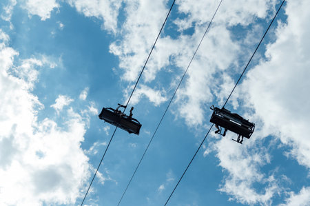 Mountain four-seater chairlift on the background of a blue cloud sky.の写真素材
