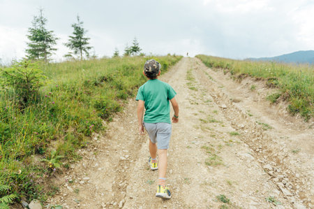 The Ukrainian boy goes up the mountain road forward. Motivating photoの写真素材