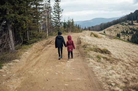 Two children - son and daughter walk around the mountain ridge by the handsの写真素材