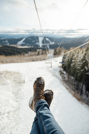 Feet in front of Chair lift during the rise to the topの写真素材