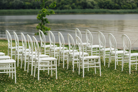 Chairs set up by the green lawn in preparation for a wedding receptionの写真素材