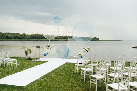Place for wedding ceremony on river beach outdoors. Large installation of round archの写真素材