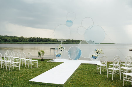 Place for wedding ceremony on river beach outdoors. Large installation of round archの写真素材