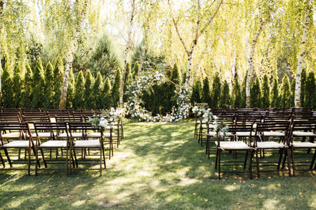 Circle wedding arch decorated with white flowers and greenery outdoors.の写真素材