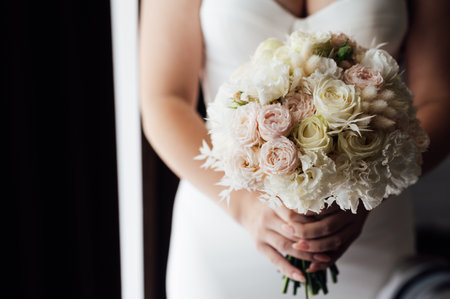 Beautiful wedding bouquet in hands of the bride. Trendy and modern wedding flowers. Soft pastelsの写真素材