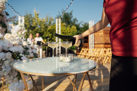Elegant glasses of champagne for the newlyweds stand on the table next to the ceremony arch