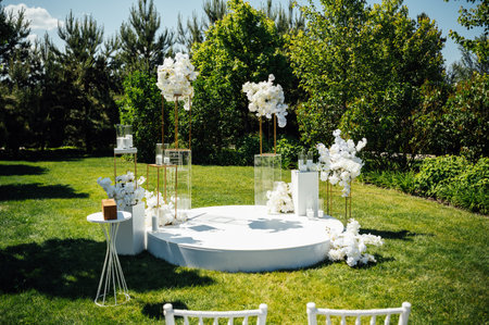 Wedding ceremony. Very beautiful and stylish wedding arch, decorated with various fresh flowers, standing in the garden.の写真素材