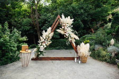 Wedding triangular arch with roses on the background of natureの写真素材