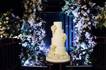 a beautiful wedding cake near the wedding arch in the eveningの写真素材