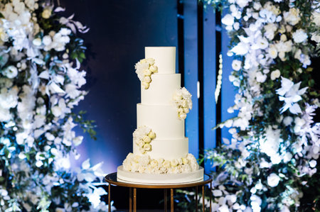 a beautiful wedding cake near the wedding arch in the eveningの写真素材