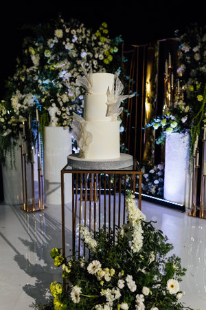 a beautiful wedding cake near the wedding arch in the eveningの写真素材