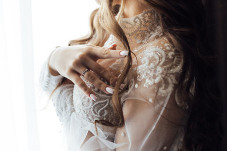 A tender bride strokes her body with her hands and sensually touches her skin. Sensual momentの写真素材
