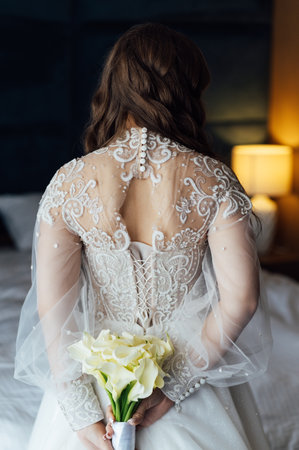 Beautiful bride in a white dress holds a beautiful bouquetの写真素材