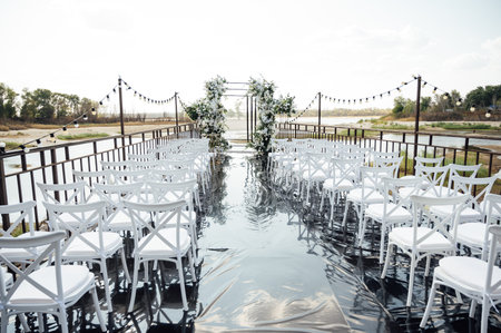 A wedding arch, decorated with flowers, stands on a podium, stands in the open airの写真素材