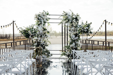 A wedding arch, decorated with flowers, stands on a podium, stands in the open airの写真素材