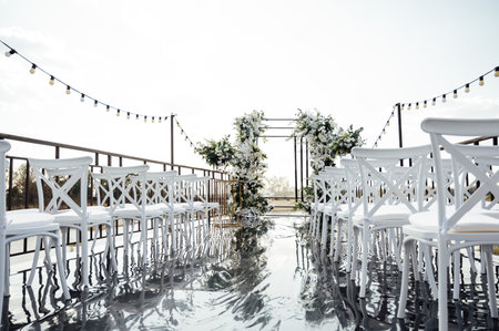 A wedding arch, decorated with flowers, stands on a podium, stands in the open airの写真素材