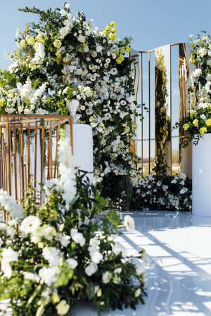A wedding arch, decorated with flowers, stands on a podium, stands in the open airの写真素材
