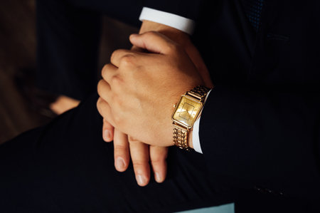 Elegant Preparation: Stylish man in a suit and with a classic gold watch on his wrist.の写真素材