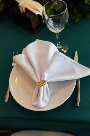 Luxurious restaurant. Luxurious interior, white tables, serving dishes and glasses for guests. Green decorの写真素材
