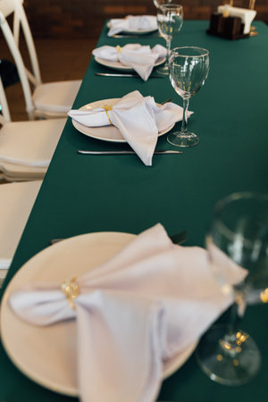 Luxurious restaurant. Luxurious interior, white tables, serving dishes and glasses for guests. Green decorの写真素材