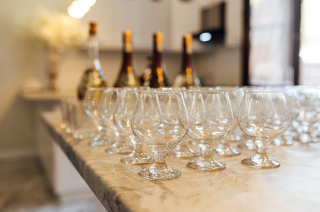 A lot of empty wine glasses. Row of clean glass transparent glasses are on a table on banquet in a barの写真素材