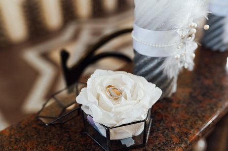 Glass box for rings. The box contains wedding rings. Burning candles stand nearbyの写真素材