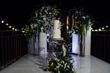 a beautiful wedding cake near the wedding arch in the eveningの写真素材
