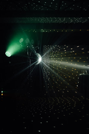 A mirrored disco ball reflects light rays throughout the room. Smoke enhances the visibilityの写真素材