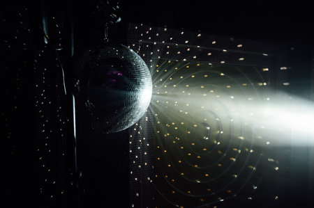 A mirrored disco ball reflects light rays throughout the room. Smoke enhances the visibilityの写真素材