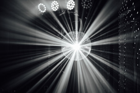A mirrored disco ball reflects light rays throughout the room. Smoke enhances the visibilityの写真素材