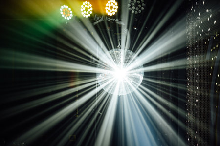 A mirrored disco ball reflects light rays throughout the room. Smoke enhances the visibilityの写真素材