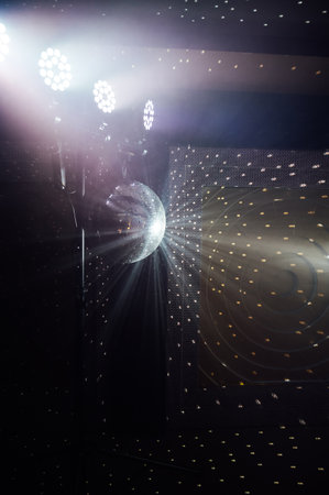 A mirrored disco ball reflects light rays throughout the room. Smoke enhances the visibilityの写真素材