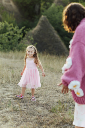 A young mother and daughter are walking in nature among the mountainsの写真素材