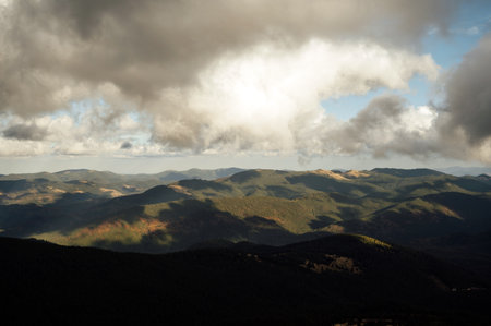 Golden autumn in the Carpathians. Beautiful clouds and sun. Image of a natural background.
