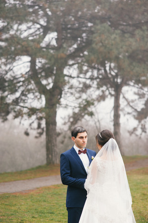 groom holds  bride by hands and looks at herの写真素材