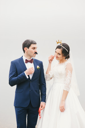 bride and groom attached to  face paper mustache ,  crownの写真素材