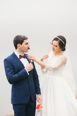 bride and groom attached to  face paper mustache and glasses Valentines Dayの写真素材