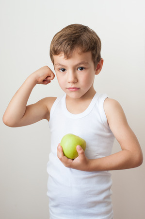 kid child muscles showing strength training apple boyの写真素材