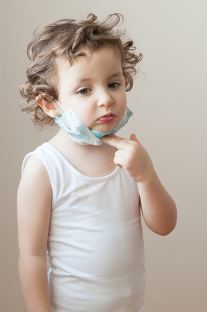 sad little girl takes a medical maskの写真素材