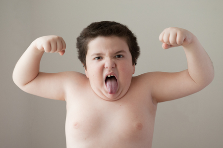 thick angry boy showing muscles and  tongueの写真素材