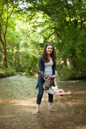 Mother and child playing in the riverの写真素材