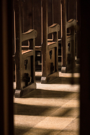 wooden bench in the Catholic Church in daytimeの写真素材
