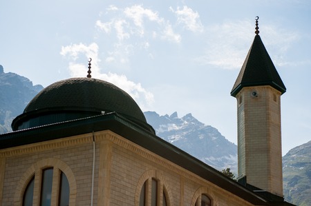 mosque on the background of snowy mountains and skyの写真素材