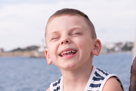 cute laughing little boy wearing striped shirtの写真素材