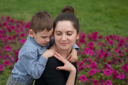 Little boy hugs a smiling motherの写真素材